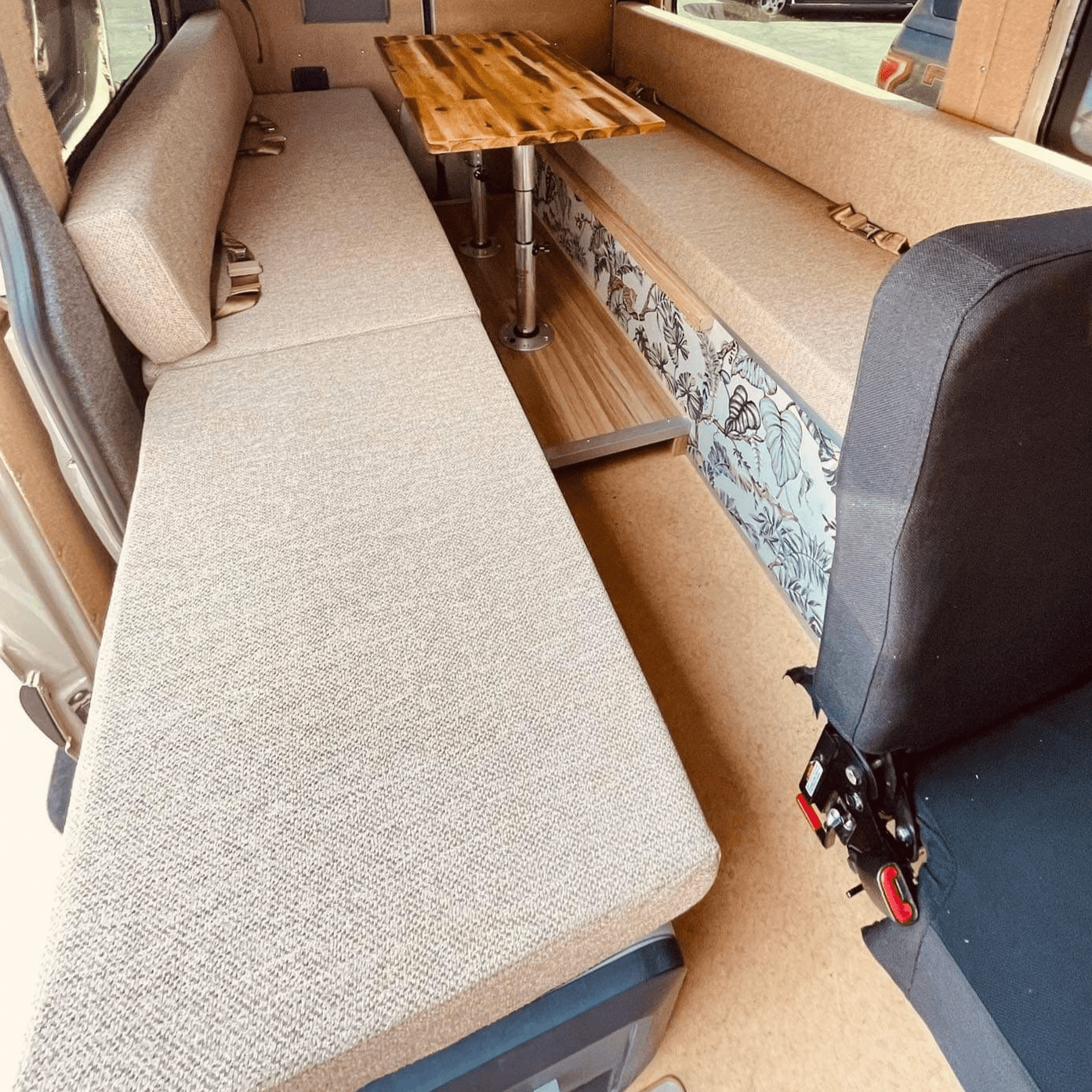 Custom skoolie cushions designed for L-shaped seating arrangements