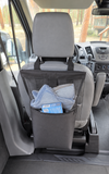 black mesh laundry bag hanging from the back of a front passenger seat inside a van, holding a light blue towel and a small blue item.